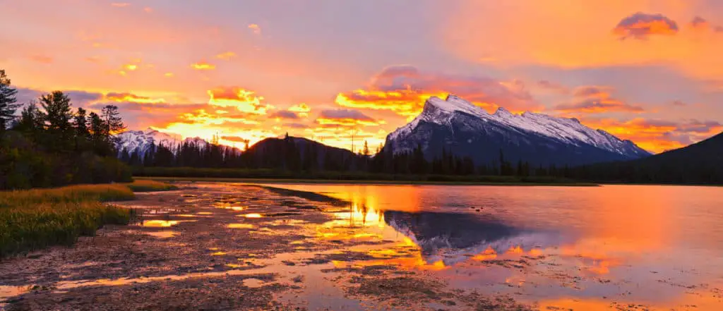 A dramatic sunset over Vermilion Lakes with Mount Rundle dominating the colorful background