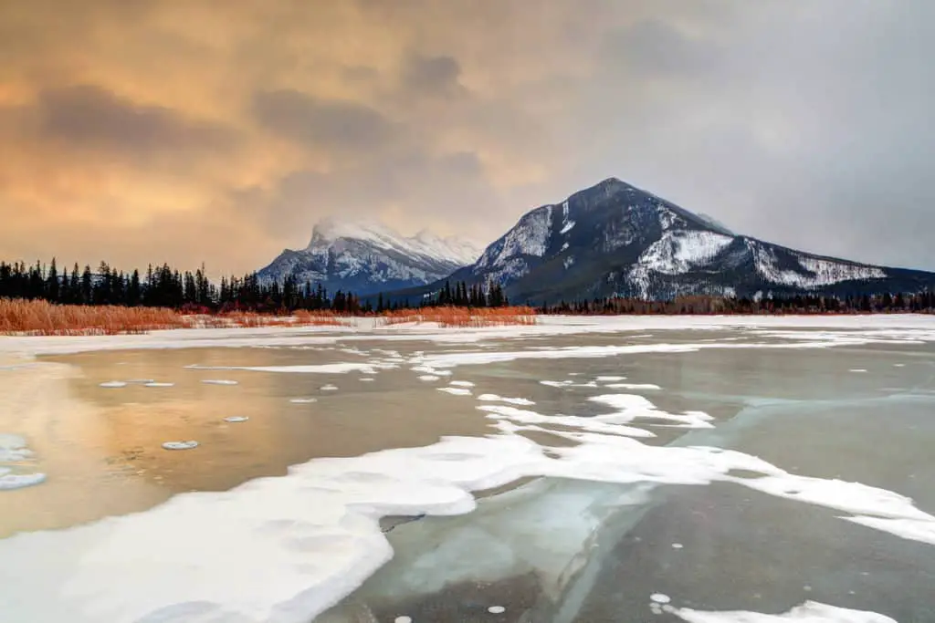 A frozen Vermilion Lakes in Banff National Park with a snow-covered Mount Rundle in the background