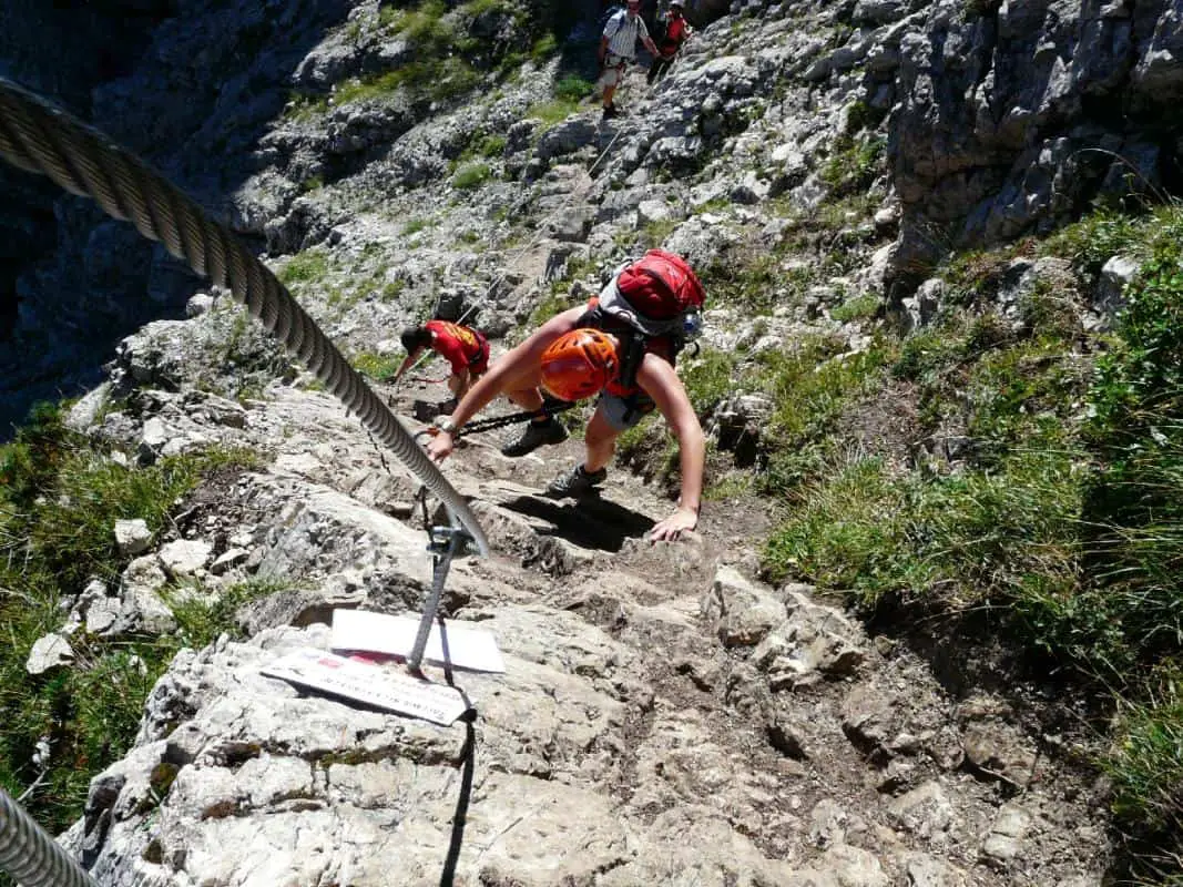 A woman holding an iron rope during a via ferrata route on Norquay Mountain in Banff National Park