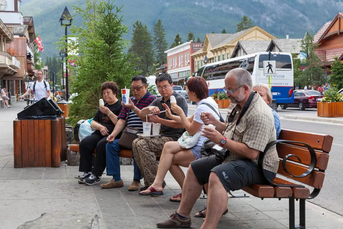 A group of people eating an ice cream on Banff Avenue in Banff