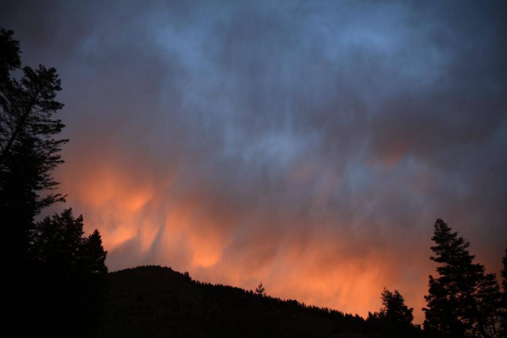 A wildfire lights up the night sky in the Rocky Mountains