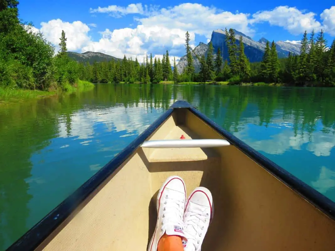 A person relaxing in a canoe on Echo Creek in Banff National Park.