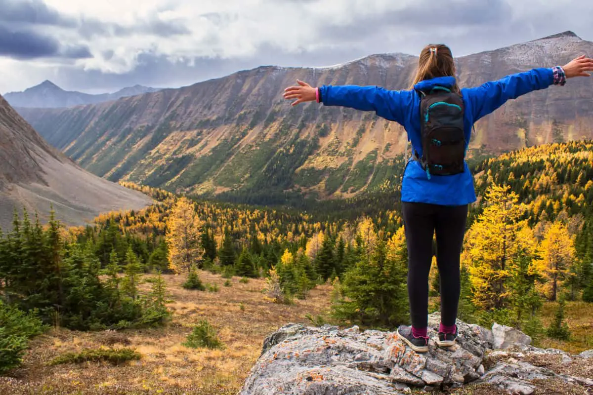 A woman stretches her arm in a valley in Banff National Park