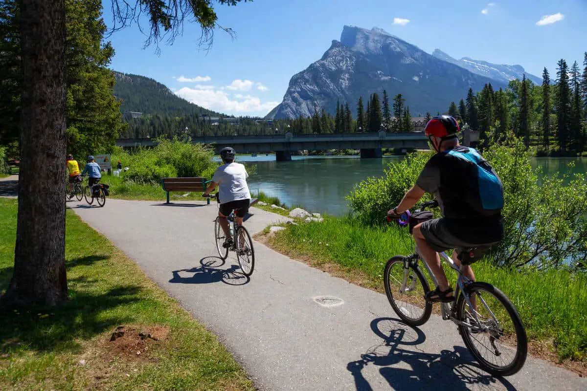 People cycling along the Bow River near the town of Banff