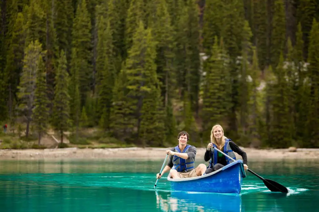 A couple canoeing on turqoise water in Banff National Park