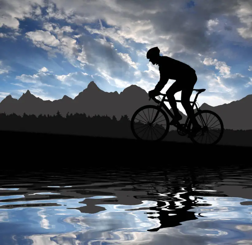 Silhouette of a cyclist cycling on a road bike in the Rocky Mountains