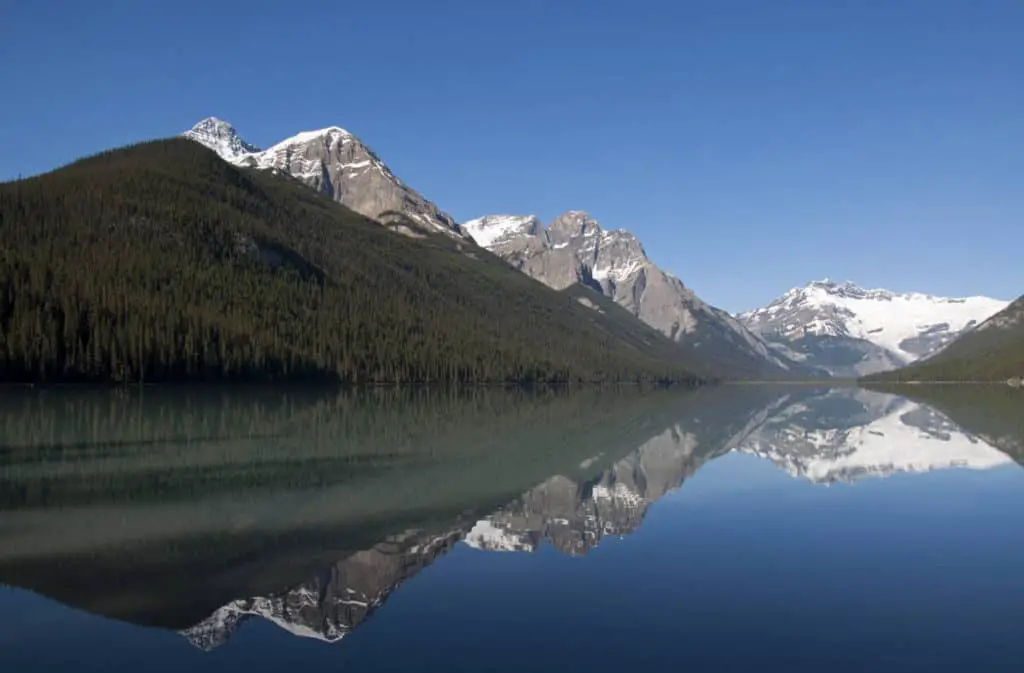 The water of Glacier Lake in Banff National Park reflects the surrounding mountains