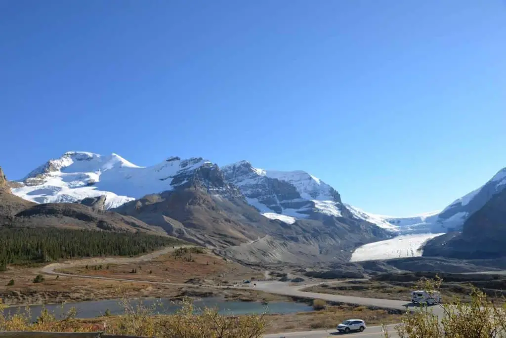 The Columbia Icefields under a clear summer sky with the Icefields Parkway in the foreground