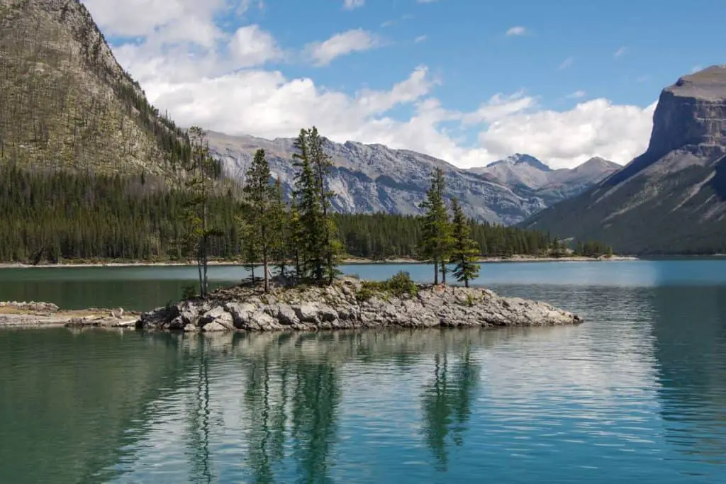 An island with a handful of trees in Lake Minnewanka near the town of Banff