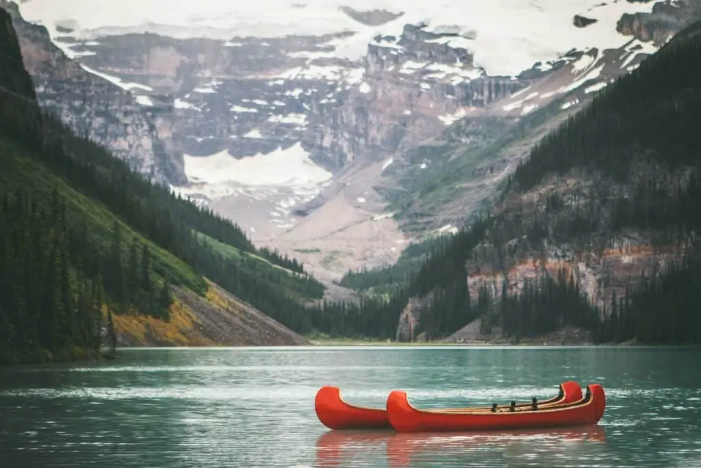 Two red canoes on Lake Louise under a cloudy sky