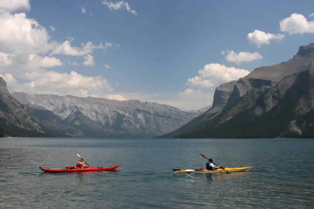 Two people kayaking on Lake Minnewanka on a summer day in Banff National Park