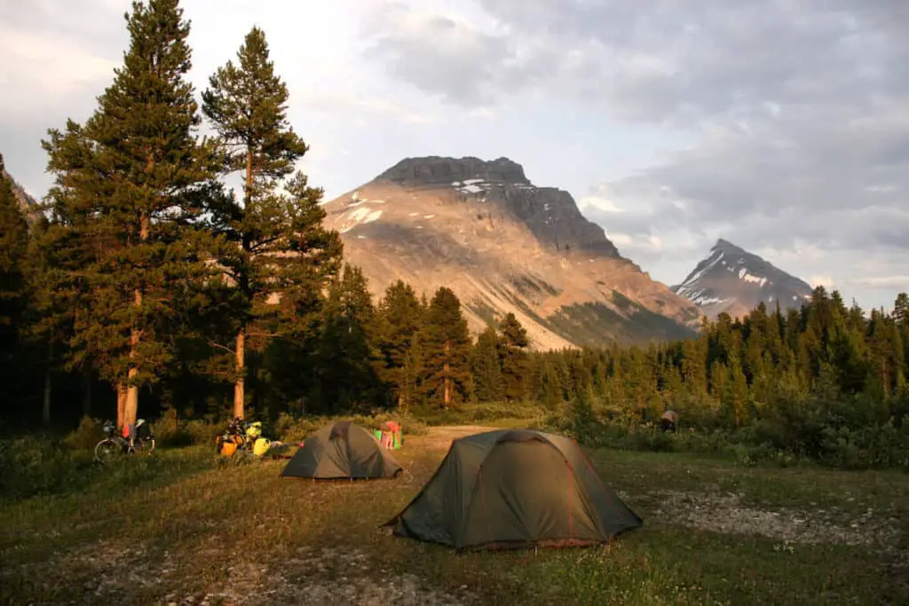 A campsite in the forest with the Rockies in the background in Banff National Park