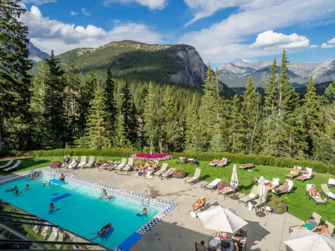 People relaxing in the hot sun at the outdoor swimming pool of the Banff Springs Hotel