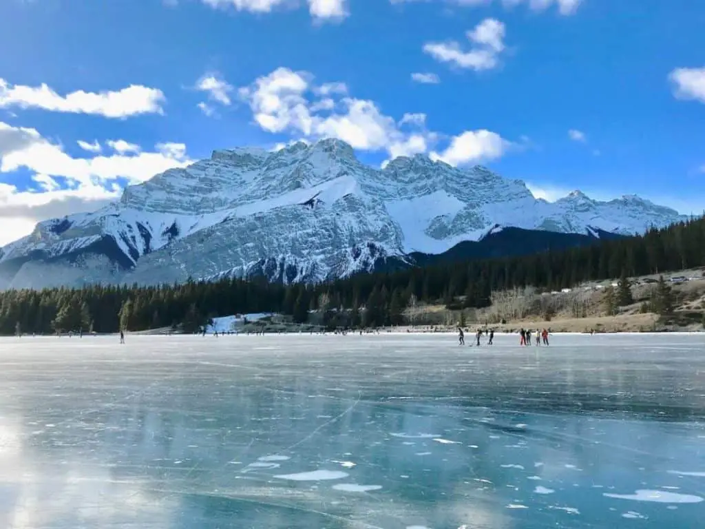 People skating on a frozen Two Jack Lake in Banff National Park