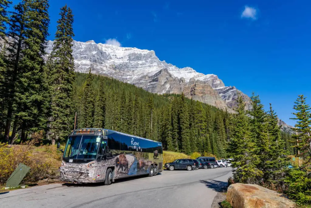 A bus of Banff's public transportation company Roam Transit arrives at the Moraine Lake parking lot