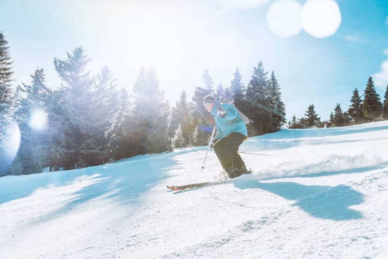 A skier skiing down a slope in January in Banff National Park