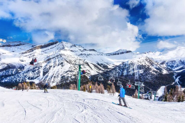 Skiers overlooking the Bow Valley near Lake Louise with a chairlift going up in the background