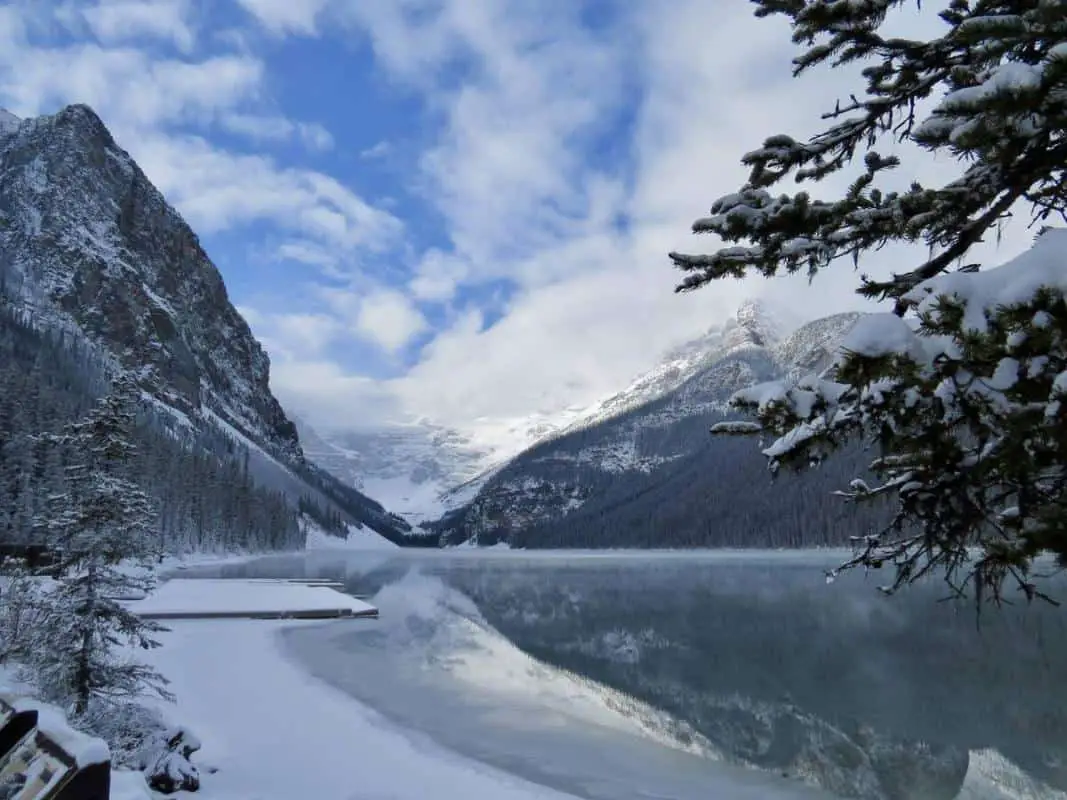 A cloudy blue sky over Lake Louise in November, its surroundings covered in snow