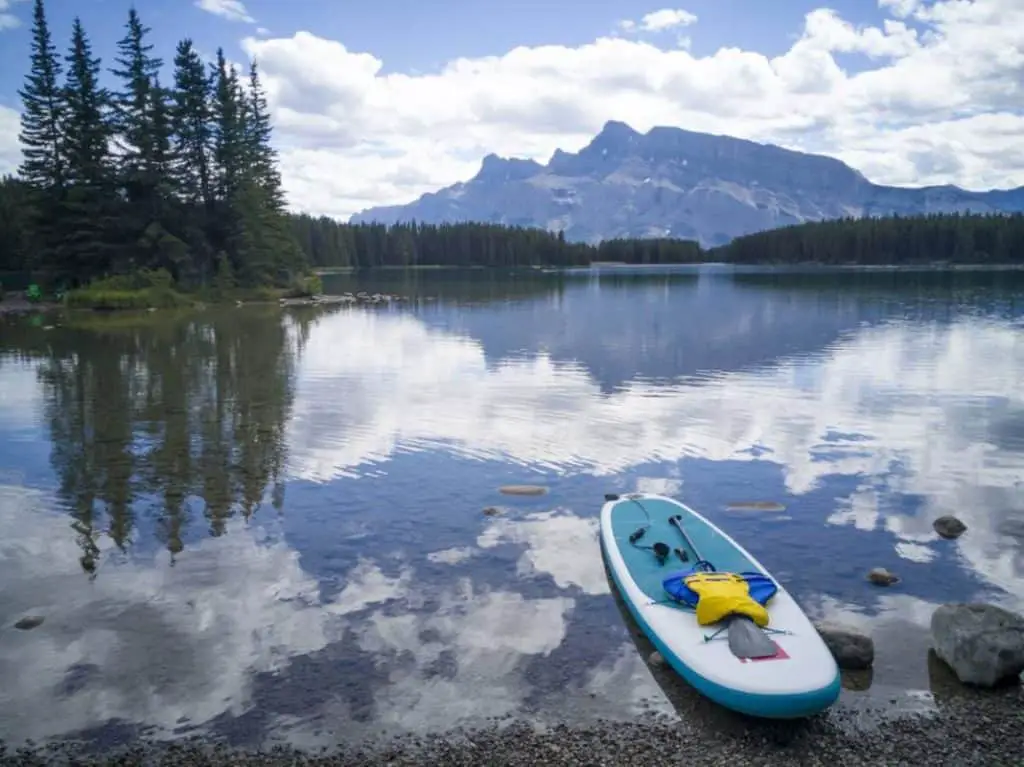 A stand-up paddleboard lying in the water, ready to be used, at Two Jack Lake in Banff