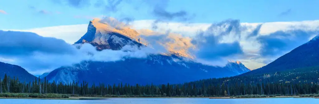 A cloud is hanging over Mount Rundle, seen from the waters of Vermilion Lakes in Banff National Park