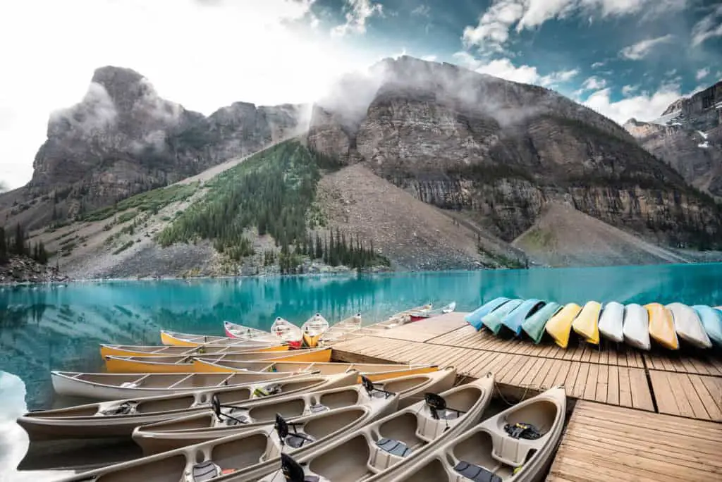 Canoes lying on the Moraine Lake dock with the lake's striking turquoise color in the background