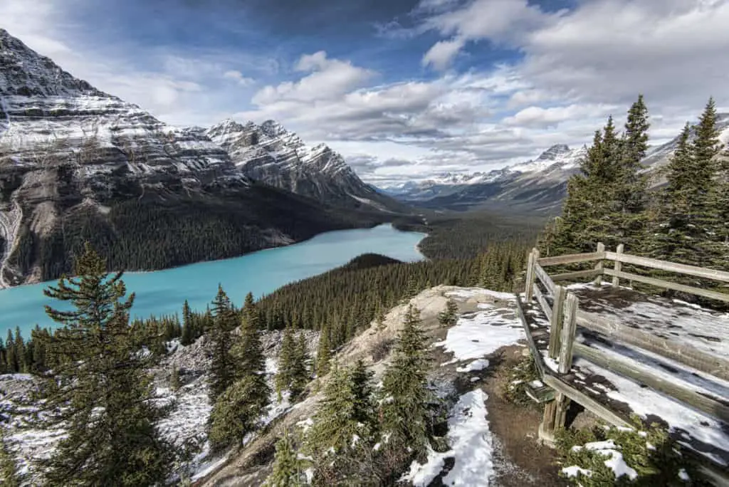A viewpoint at the thawed Peyto Lake in June on a cloudy day, with some last remains of snow on the mountain slopes
