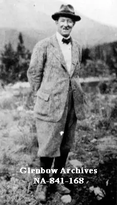 Walter D. Wilcox wearing a hat and with his hands on his back in the Rocky Mountains in Alberta