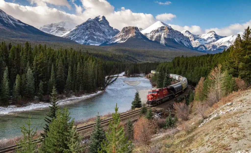 A freight trein passes through Morant's Curve along the Bow Valley Parkway