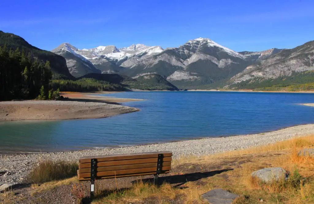 A bench at the shore of Barrier Lake in Kananaskis Country in Alberta, Canada