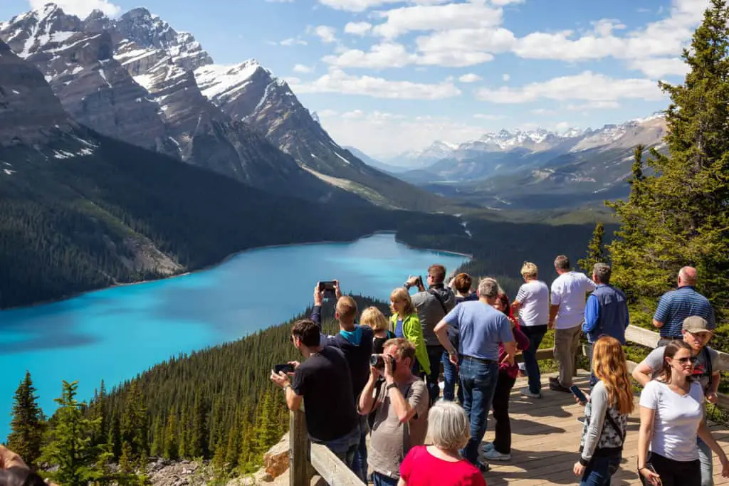 Tourists on the Peyto Lake viewing deck admiring the spectacular surroundings in Banff National Park