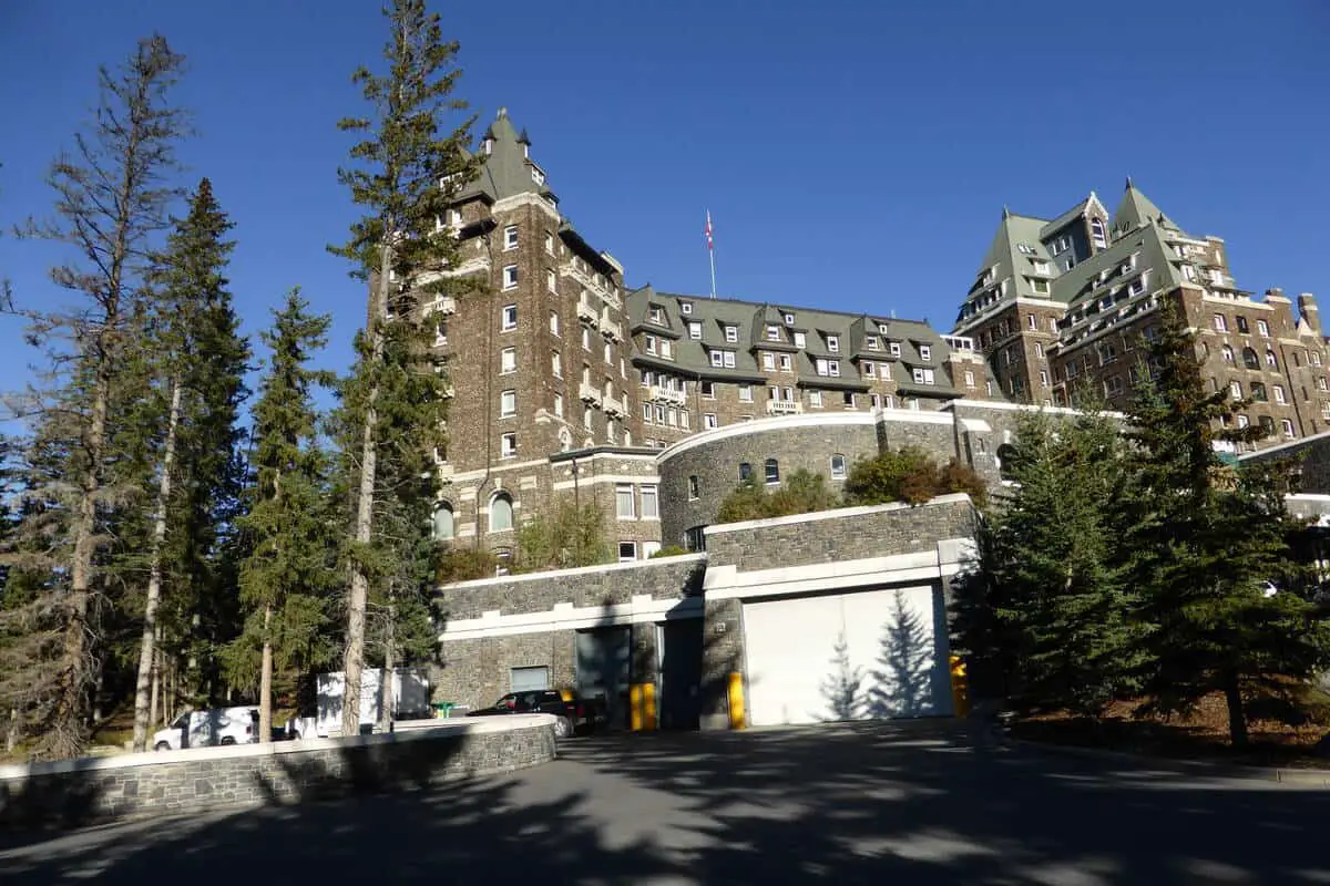The front of the exterior of the Fairmont Banff Springs hotel accompanied with several spruce trees