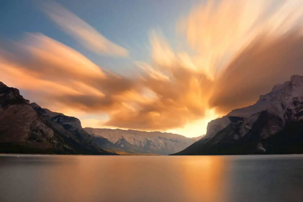 A stunning golden sky over Lake Minnewanka in the Canadian Rocky Mountains during sunset