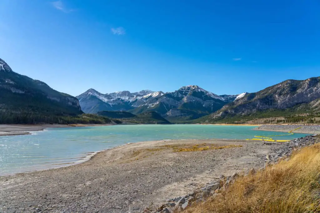 The turqoise water of Barrier Lake in Kananaskis Country under a clear blue sky