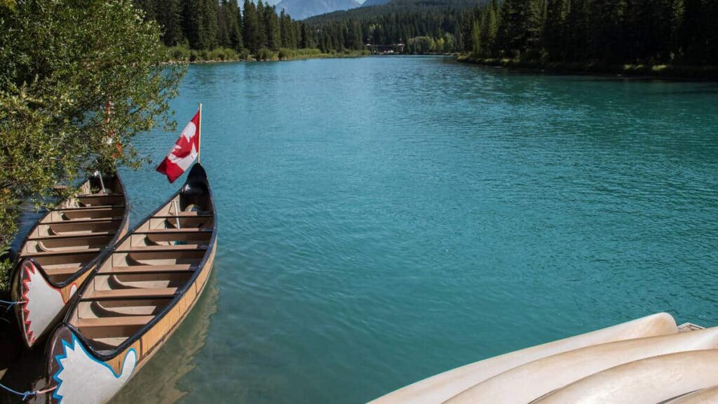 Two canoes lying in the turquoise waters of the Bow River near the town of Banff