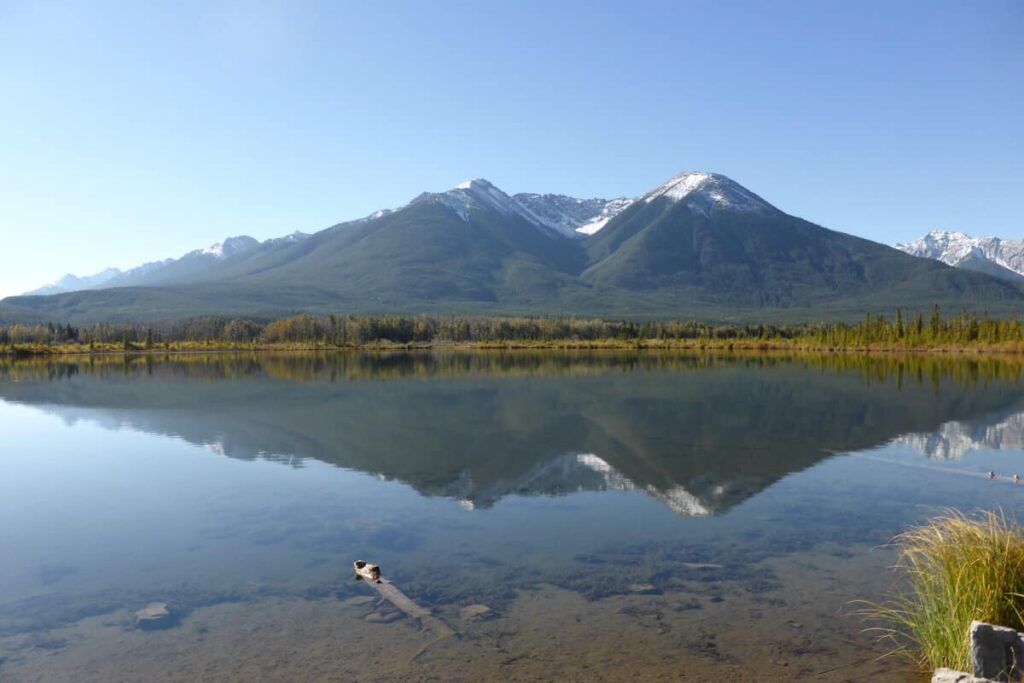 The tranquil blue waters of Vermilion Lakes near the town of Banff under a cloudless sky