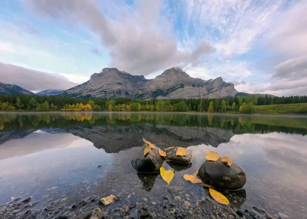 The still waters of Wedge Pond in Kananaskis Country perfectly reflects mountains surrounding it