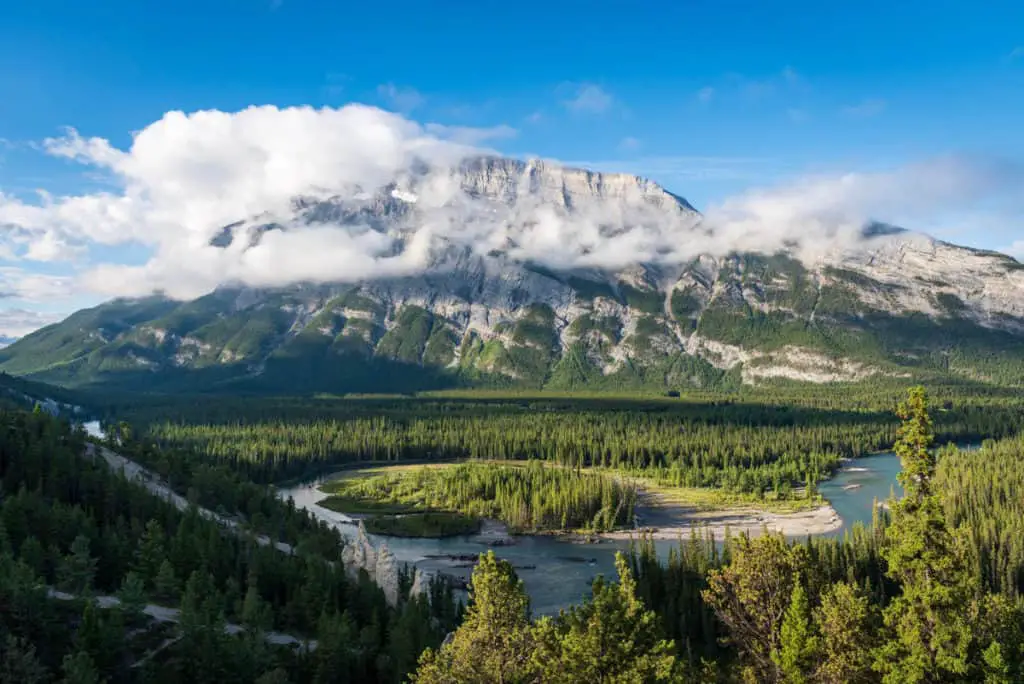 The hoodoos rock formation on the slopes of Tunnel Mountain with the Bow River and a misty Rundle Mountain in the background