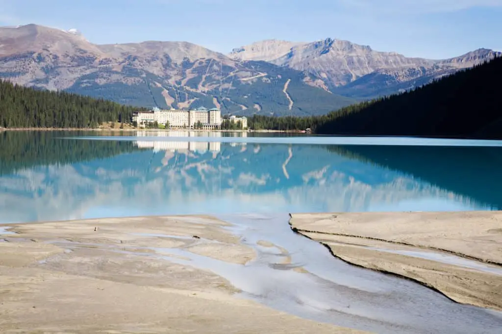 The historical Château Lake Louise at the lakeshore, seen from the opposite side of Lake Louise