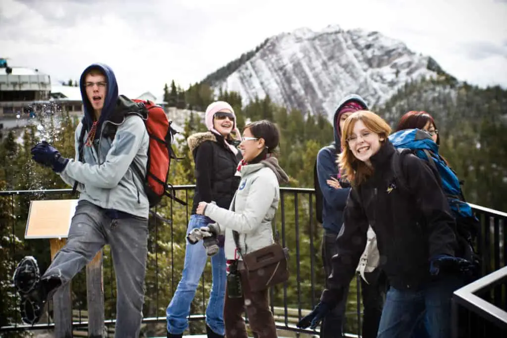 Kids throwing snowballs at each other at the summit of Sulphur Mountain in Banff National Park