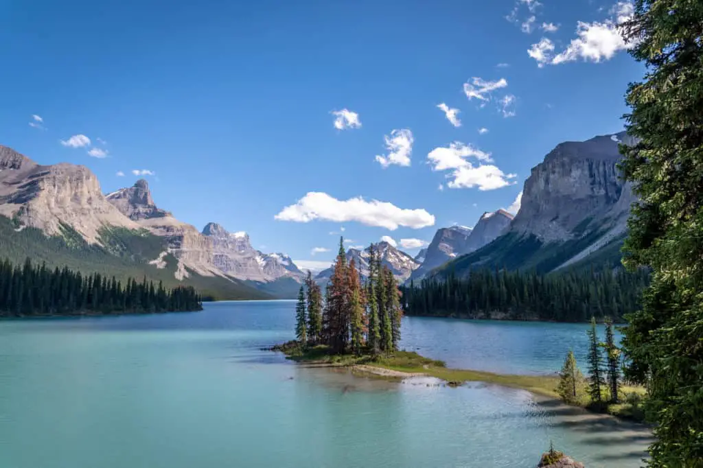 Maligne Lake under a blue sky in Jasper National Park with small peninsula Spirit Island stretching into the lake