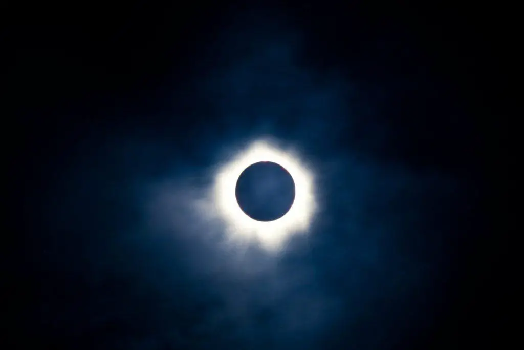 A full solar eclipse creating a ring of light around the moon in a dark sky
