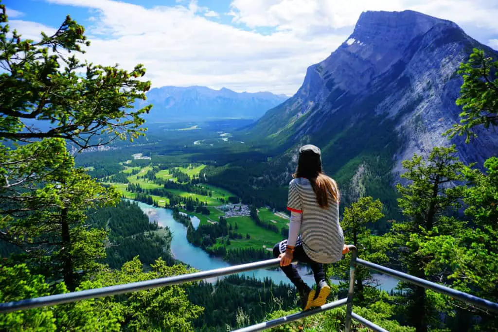 A woman enjoying the view on the Banff Golf Course, the Bow River and Rundle Mountain from a Tunnel Mountain viewpoint
