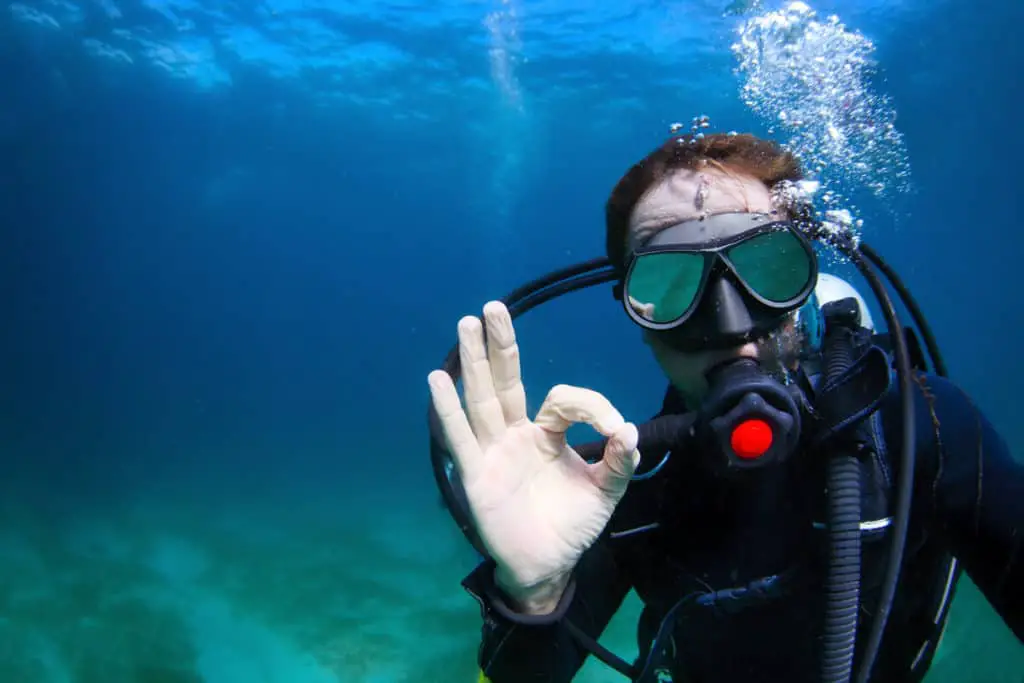 A diver giving the ok sign during a diving trip in Lake Minnewanka in Banff National Park