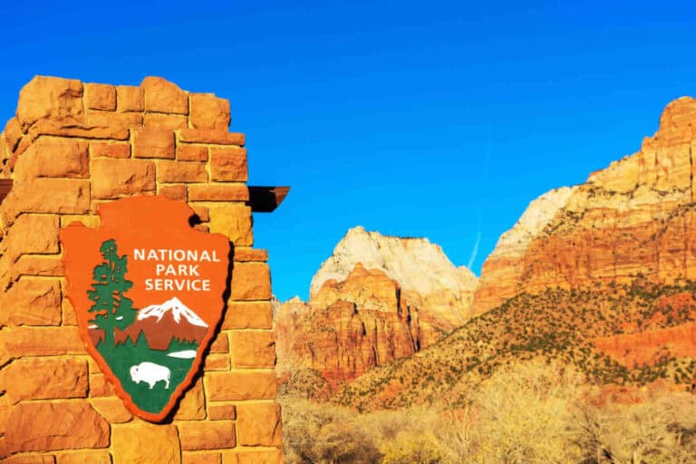 A sign of the National Park Service on a brick stone wall in Zion National Park.