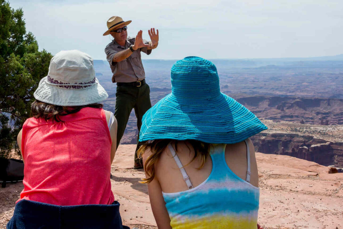 An NPS park ranger explaining two tourists something in Grand Canyon National Park.