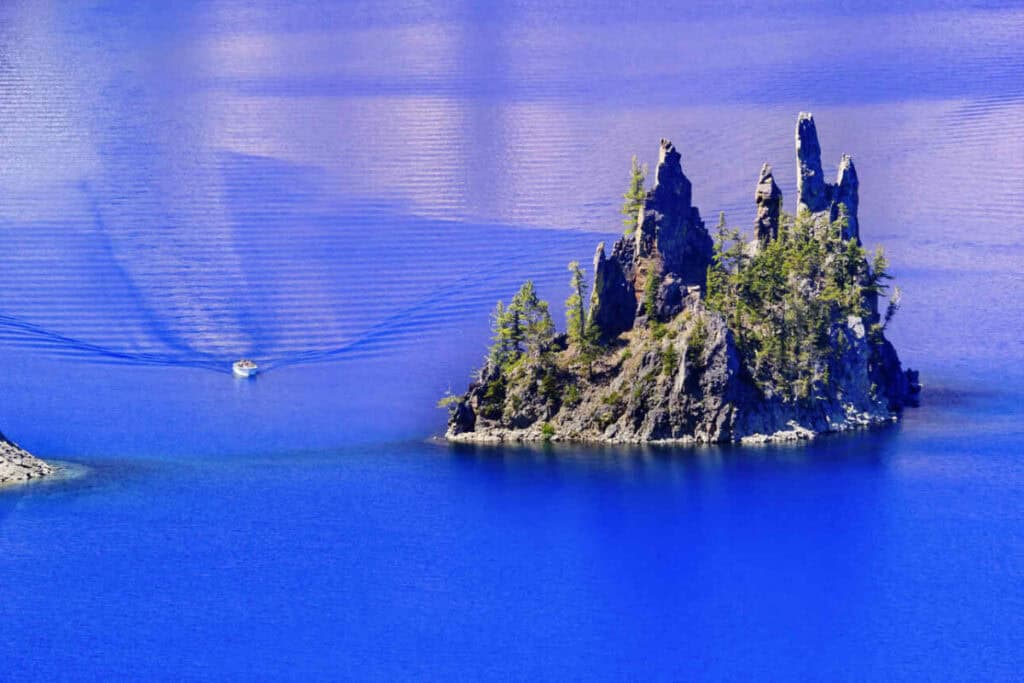 A boat approaching Phantom Ship Island in Crater Lake National Park in Oregon.
